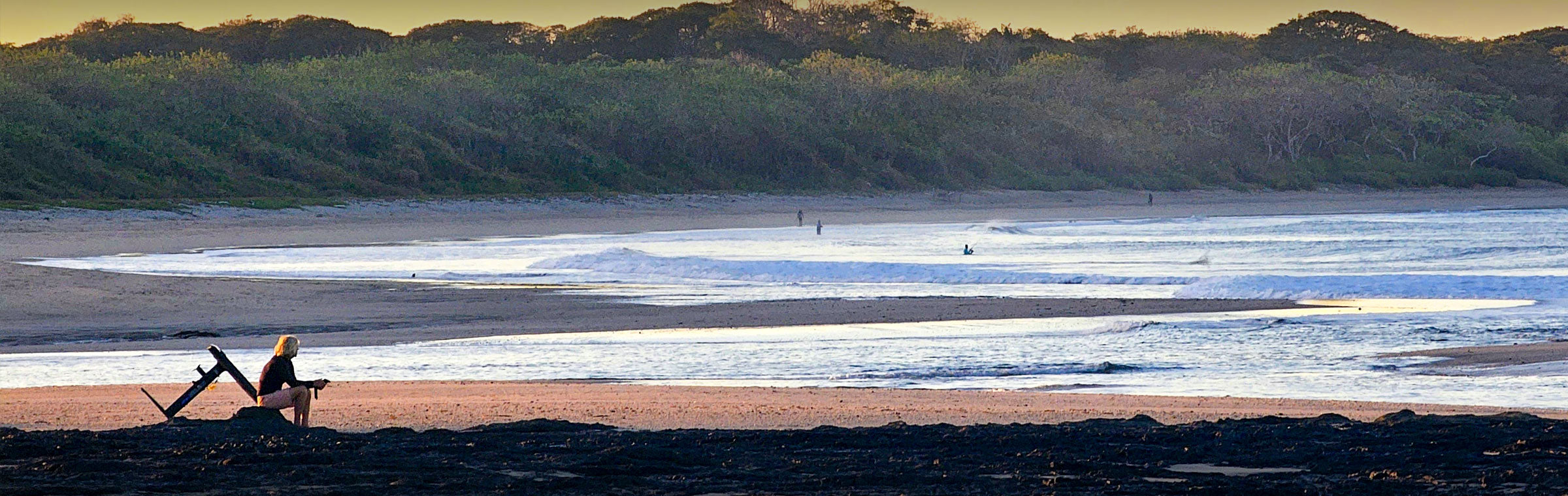 Foiler sitting on the rocks checking the surf